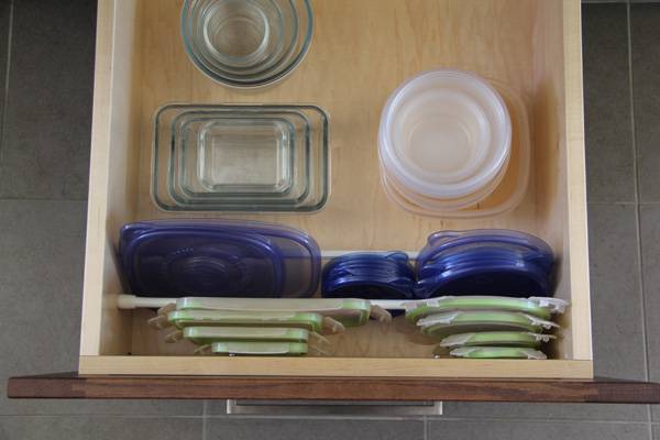 20+ Creative Uses of Tension Rods to Organize Your Home --> Use Tension Rod to Keep Plastic Lids in Place in the Drawer