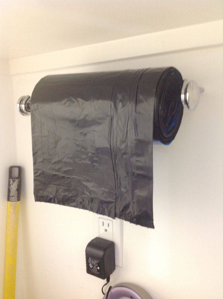30+ Creative Ways to Organize Your Garage --> Use a paper towel holder as a dispenser for a large garbage bag roll