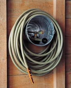 30+ Creative Ways to Organize Your Garage --> Store garden hose and sprinklers in a bucket hanging from the wall