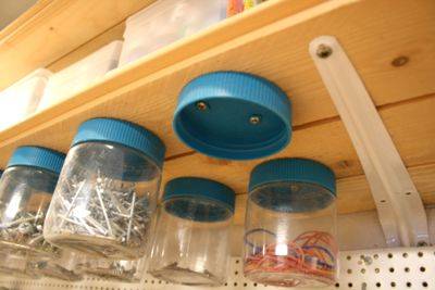 30+ Creative Ways to Organize Your Garage --> Mount the lids of recycled plastic jars to the bottom of wooden shelves and use them to store screws, nails and other small objects