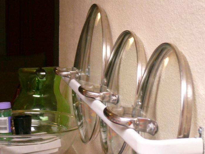 40+ Organization and Storage Hacks for Small Kitchens --> Organize pot lids with a towel rack